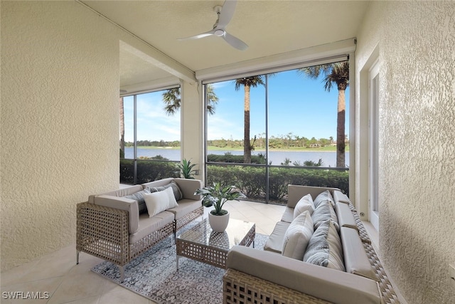 sunroom / solarium with ceiling fan and a water view