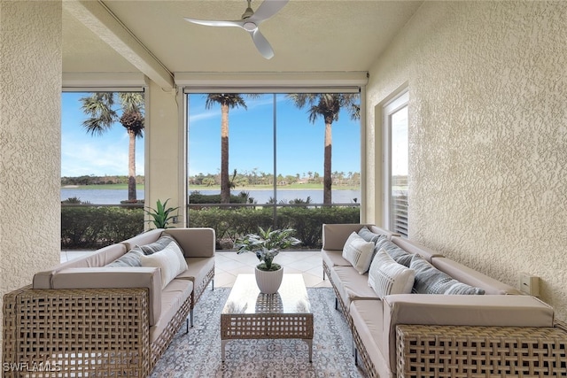 sunroom / solarium featuring ceiling fan and a water view