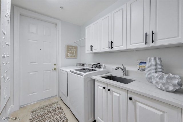 laundry area with sink, cabinets, light tile patterned flooring, and washing machine and clothes dryer