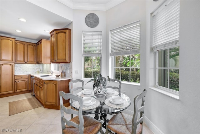 dining room featuring sink, light tile patterned floors, and crown molding