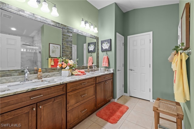 bathroom with tile patterned flooring, vanity, and tiled shower