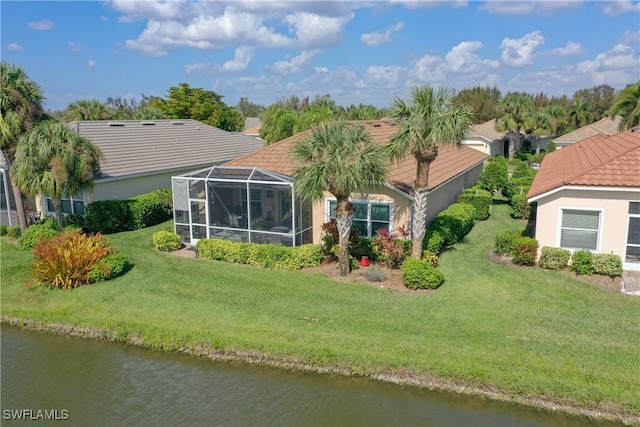 back of property featuring a water view, glass enclosure, and a lawn