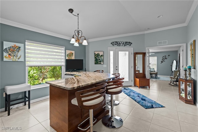 interior space with light stone countertops, a chandelier, ornamental molding, and light tile patterned flooring