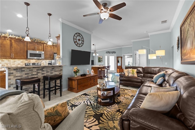 living room with ceiling fan, light tile patterned flooring, ornamental molding, and vaulted ceiling