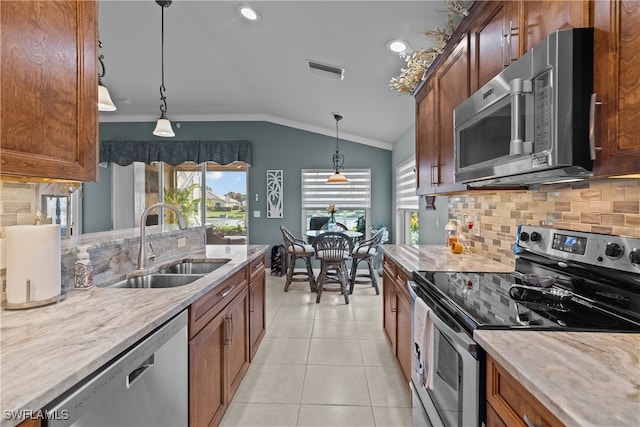 kitchen with backsplash, sink, vaulted ceiling, decorative light fixtures, and stainless steel appliances