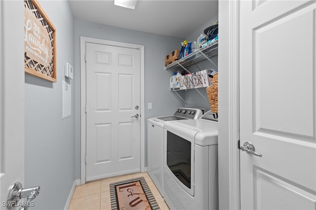 laundry area featuring washer and clothes dryer and light tile patterned flooring