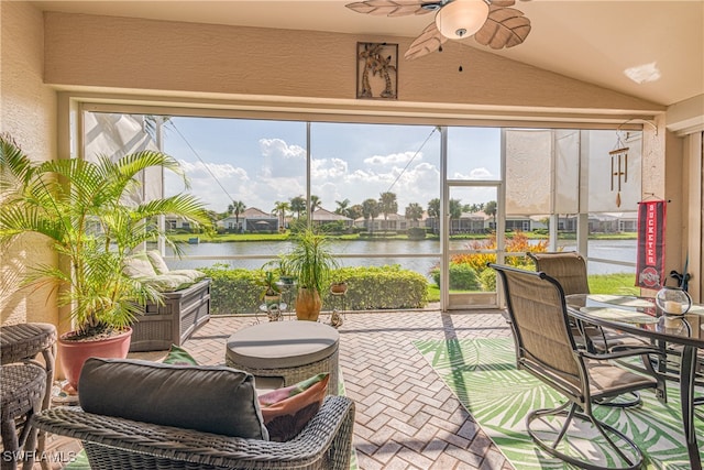 sunroom featuring a water view, vaulted ceiling, and ceiling fan