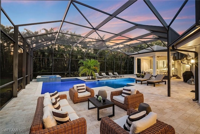 pool at dusk with an outdoor living space, ceiling fan, a lanai, an in ground hot tub, and a patio area