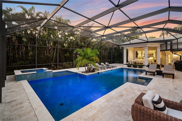 pool at dusk featuring an outdoor living space, a lanai, an in ground hot tub, and a patio