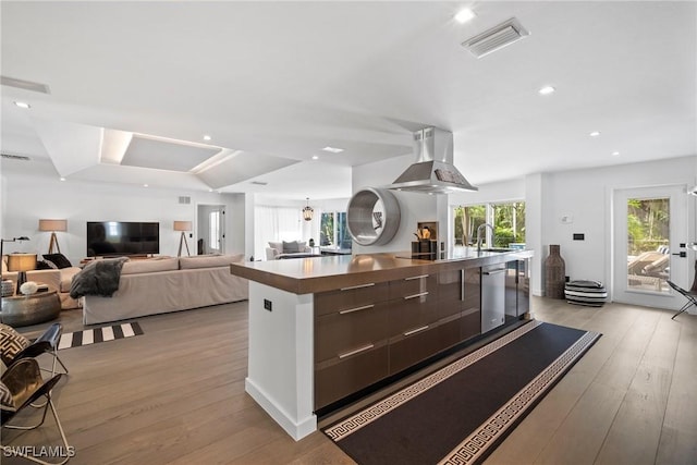 kitchen with sink, a spacious island, island range hood, black electric cooktop, and light wood-type flooring