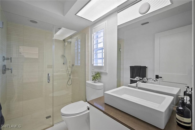 bathroom featuring toilet, vanity, and walk in shower