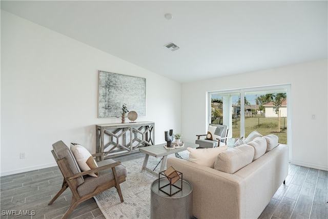 living room featuring dark hardwood / wood-style flooring and vaulted ceiling