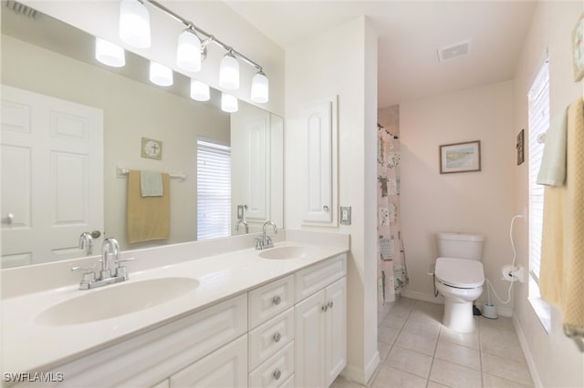 bathroom with tile patterned flooring, vanity, toilet, and curtained shower