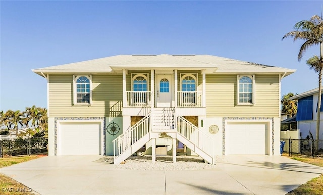 coastal inspired home with a porch and a garage