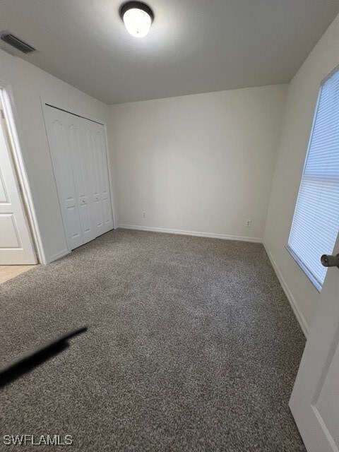 unfurnished bedroom featuring a closet and carpet