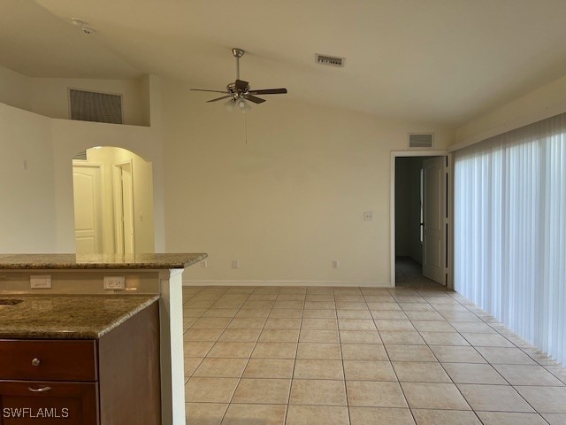 interior space with ceiling fan, light tile patterned floors, and lofted ceiling