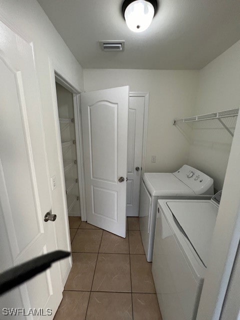 washroom with washing machine and clothes dryer and tile patterned flooring