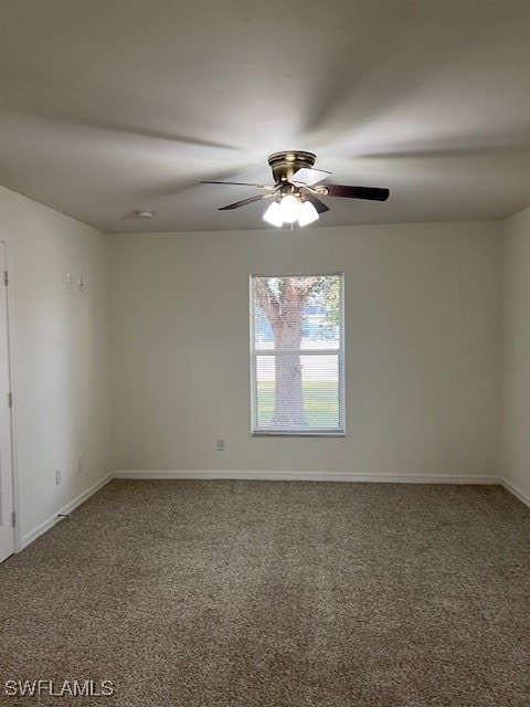 carpeted spare room featuring ceiling fan