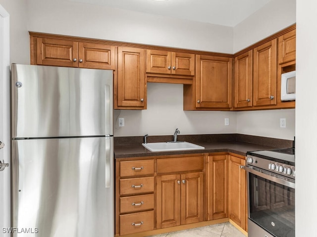 kitchen with sink, light tile patterned floors, and stainless steel appliances