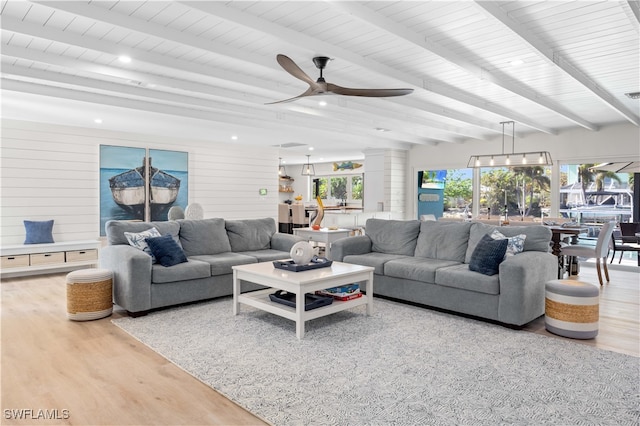 living room featuring hardwood / wood-style flooring, ceiling fan, ornate columns, and beamed ceiling