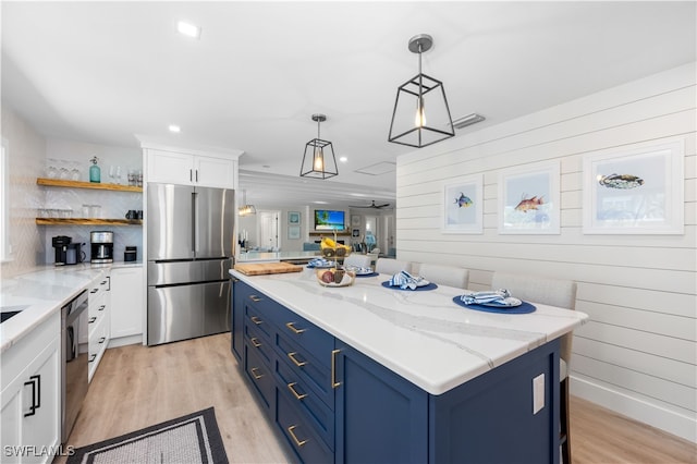 kitchen featuring a center island, light wood-type flooring, blue cabinetry, white cabinetry, and stainless steel appliances