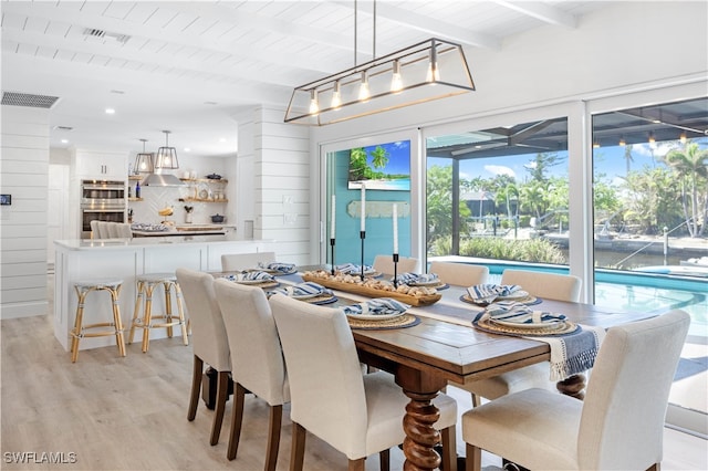 dining space featuring beam ceiling, light hardwood / wood-style floors, wooden walls, and wood ceiling