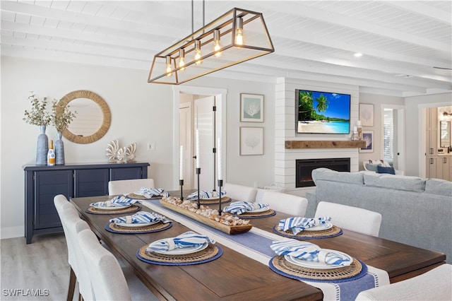 dining room featuring light hardwood / wood-style floors, wood ceiling, and beam ceiling