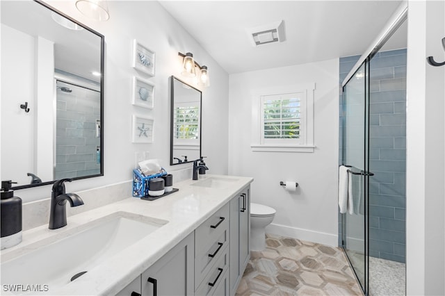 bathroom with tile patterned flooring, vanity, an enclosed shower, and toilet