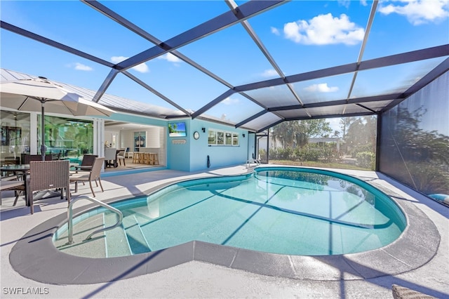 view of pool with glass enclosure and a patio area