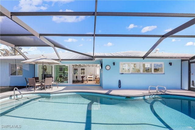 view of swimming pool featuring ceiling fan, a lanai, and a patio