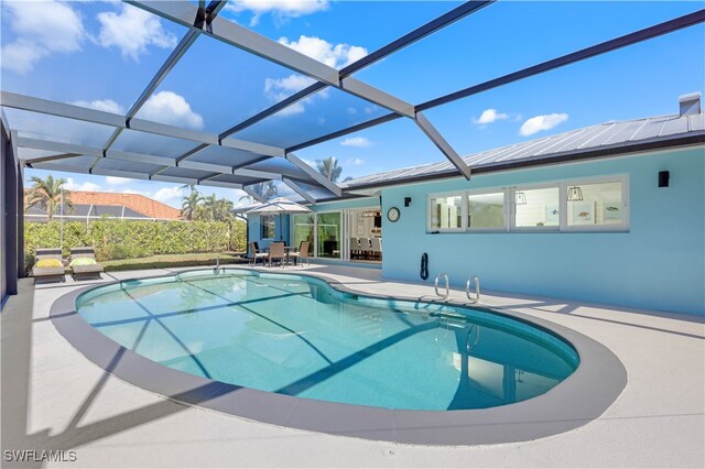 view of pool featuring a patio area and glass enclosure