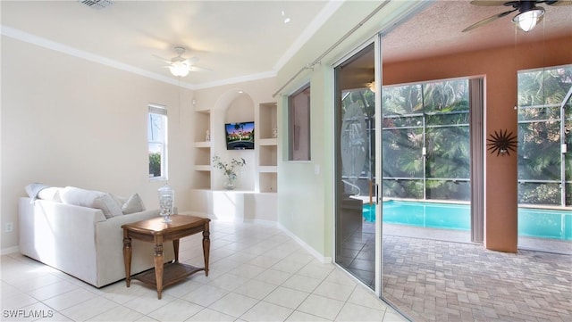 tiled living room with ceiling fan, built in features, crown molding, and a textured ceiling