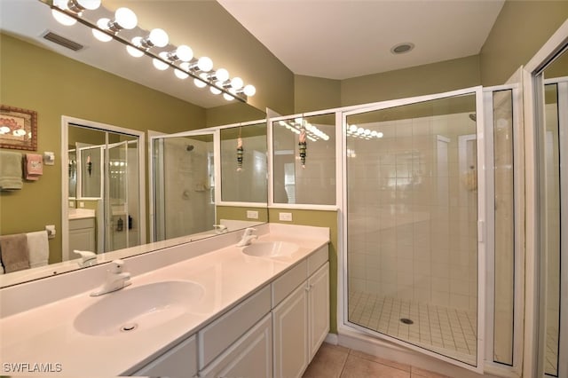 bathroom featuring tile patterned flooring, an enclosed shower, and vanity