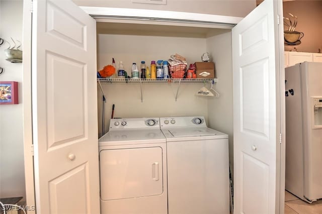 laundry room with washing machine and clothes dryer and light tile patterned floors