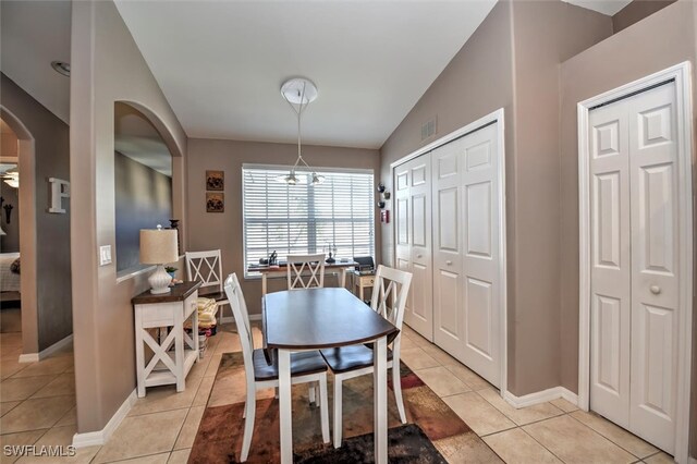 tiled dining room featuring lofted ceiling