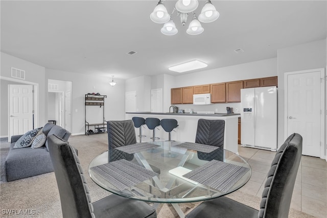 dining area with light tile patterned flooring and an inviting chandelier