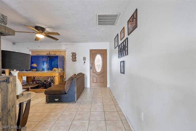 living area with light tile patterned floors, visible vents, and ceiling fan