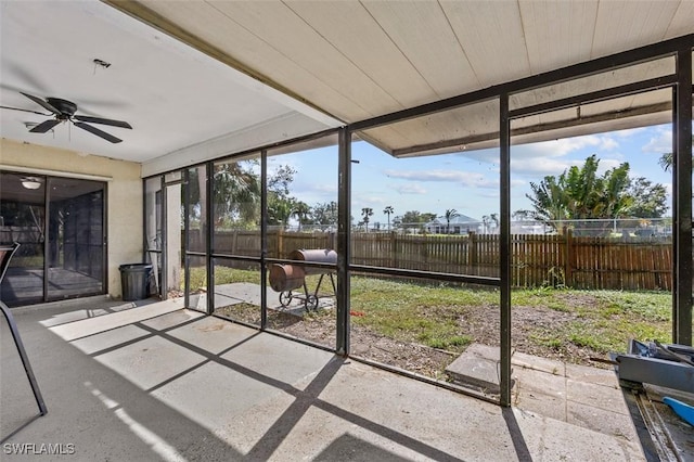 unfurnished sunroom featuring a ceiling fan