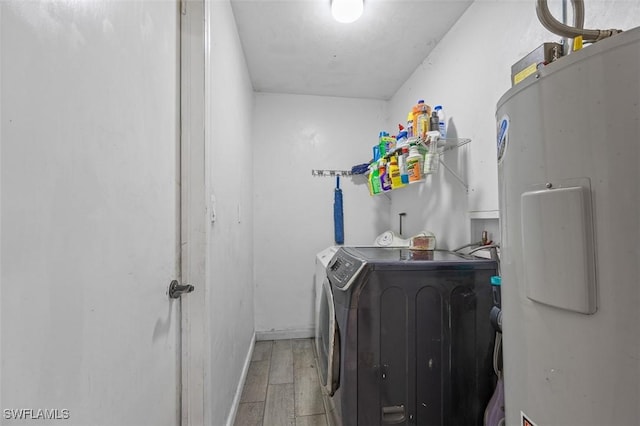 laundry room with baseboards, light wood finished floors, laundry area, separate washer and dryer, and electric water heater