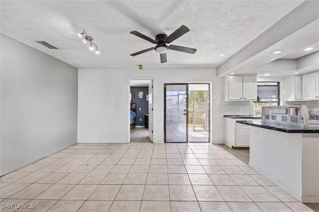 kitchen with light tile patterned floors, visible vents, white cabinets, and ceiling fan