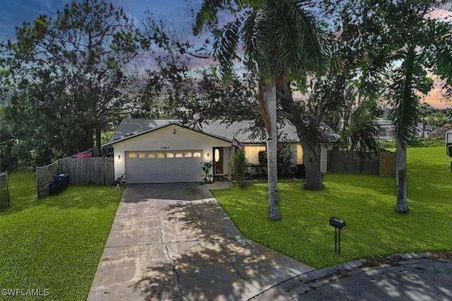 ranch-style house with a garage and a lawn