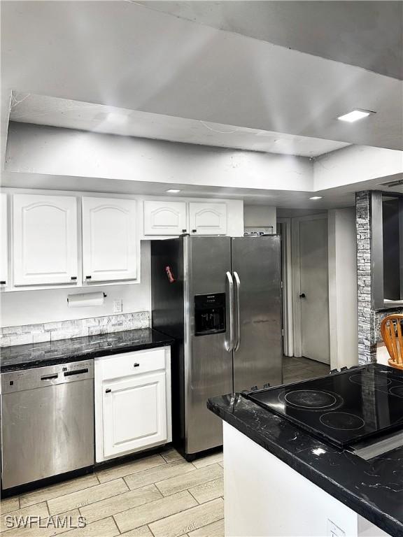 kitchen with white cabinetry, stainless steel appliances, and wood finish floors