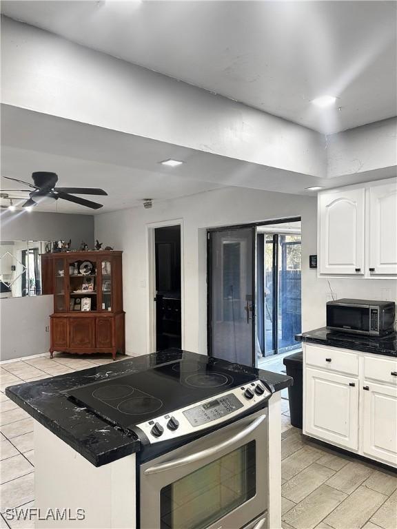 kitchen featuring a kitchen island, white cabinets, stainless steel appliances, and ceiling fan