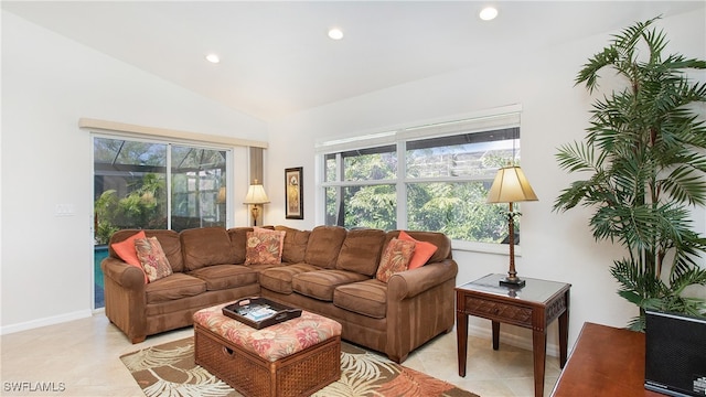 living room with a wealth of natural light, vaulted ceiling, and light tile patterned flooring