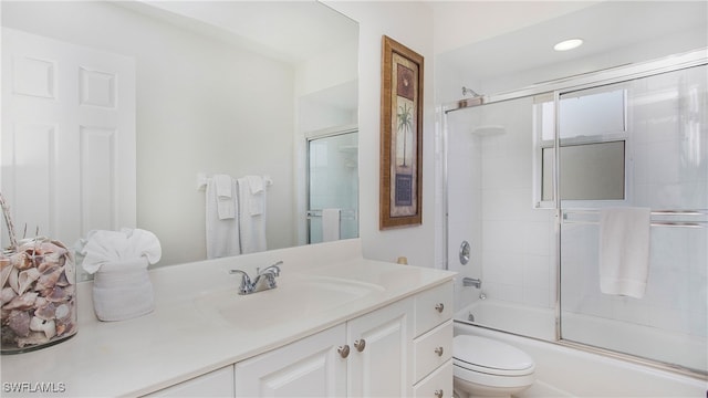 full bathroom with bath / shower combo with glass door, vanity, and toilet