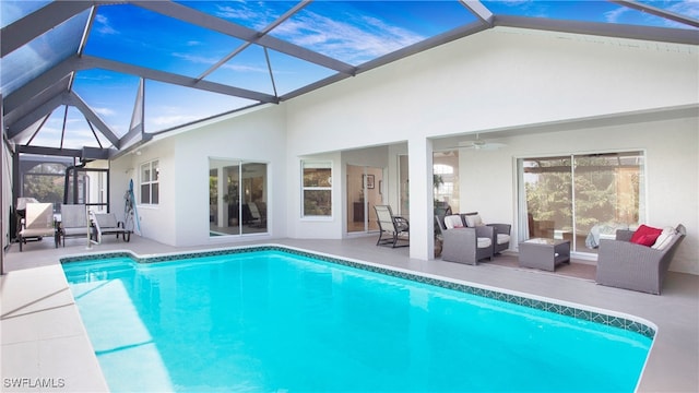 view of swimming pool featuring ceiling fan, a patio, a lanai, and an outdoor hangout area