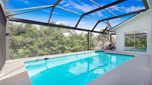 view of swimming pool featuring glass enclosure and a patio area