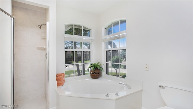 bathroom featuring a healthy amount of sunlight, toilet, and independent shower and bath