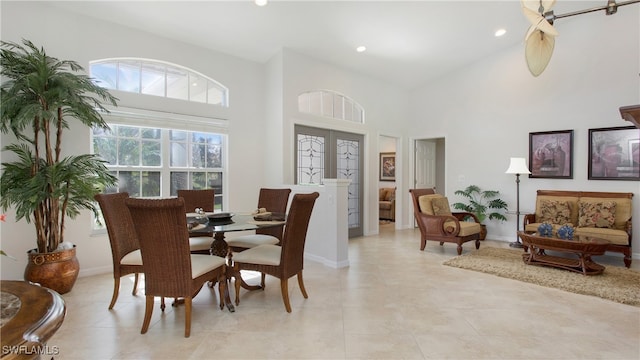 tiled dining space featuring high vaulted ceiling