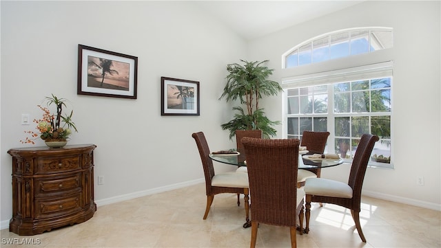 dining area with light tile patterned flooring and vaulted ceiling